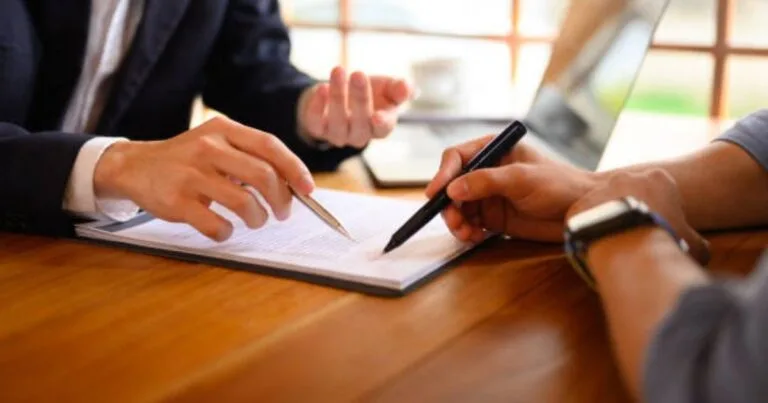 Consultant discussing business goals and marketing needs with client during strategy meeting.